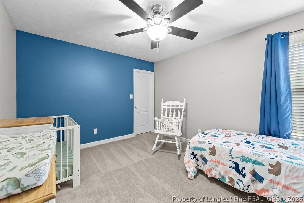 259 Bayleaf Drive Raeford, NC 28376 - Photo 26 of 46 a bedroom with a bed and a chandelier