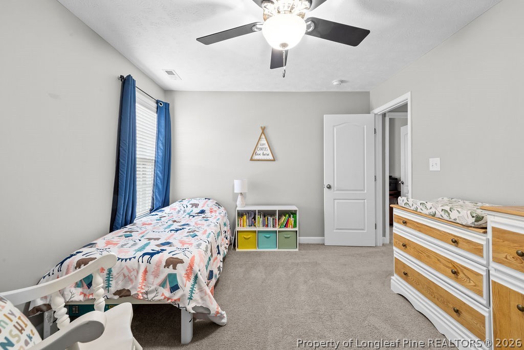 259 Bayleaf Drive Raeford, NC 28376 - Photo 27 of 46 a bedroom with a bed and a chandelier