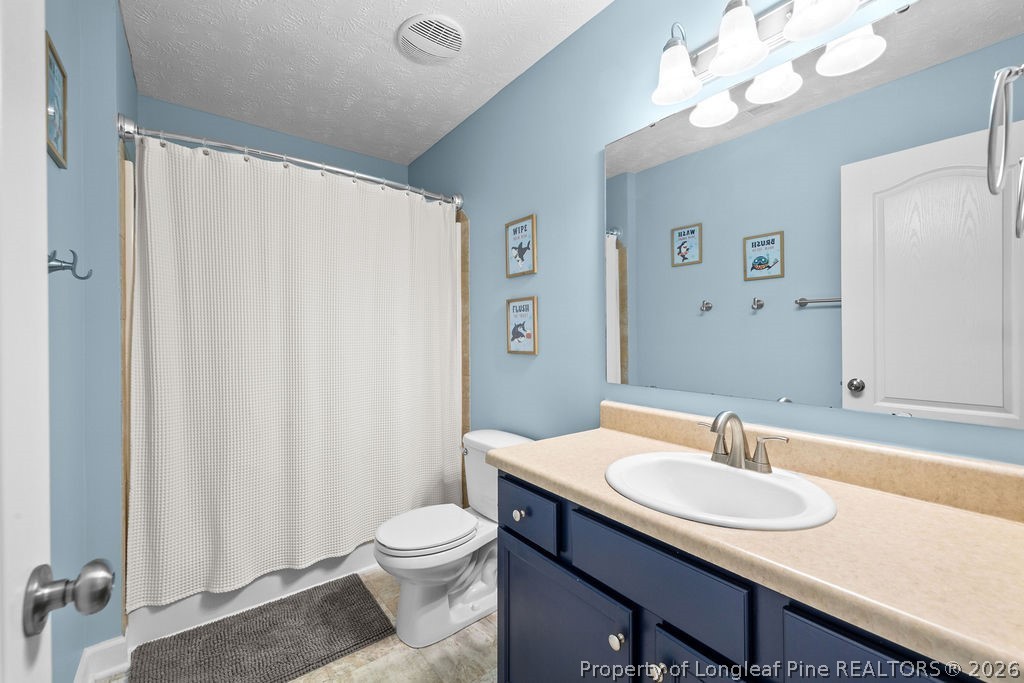 259 Bayleaf Drive Raeford, NC 28376 - Photo 28 of 46 a bathroom with a sink a toilet and a mirror