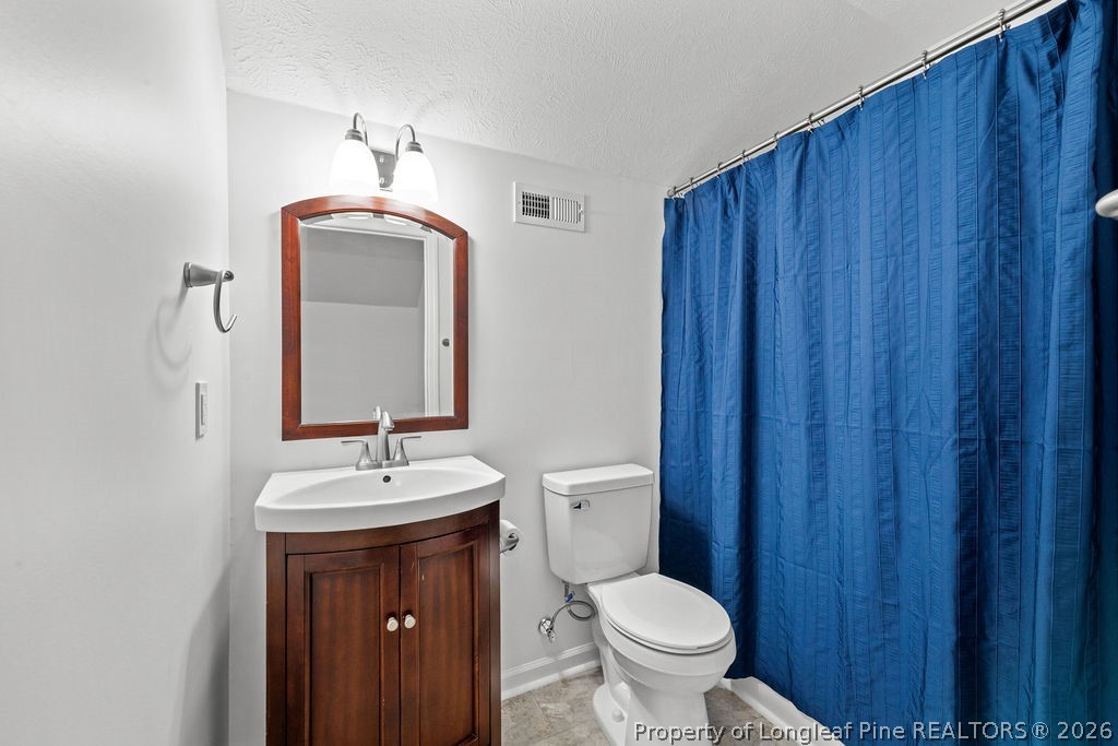 259 Bayleaf Drive Raeford, NC 28376 - Photo 33 of 46 a bathroom with a toilet a sink and a mirror