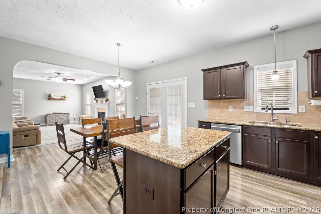 259 Bayleaf Drive Raeford, NC 28376 - Photo 9 of 46 a kitchen with granite countertop a table chairs sink and wooden floor
