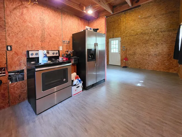 a view of a refrigerator in kitchen and empty room