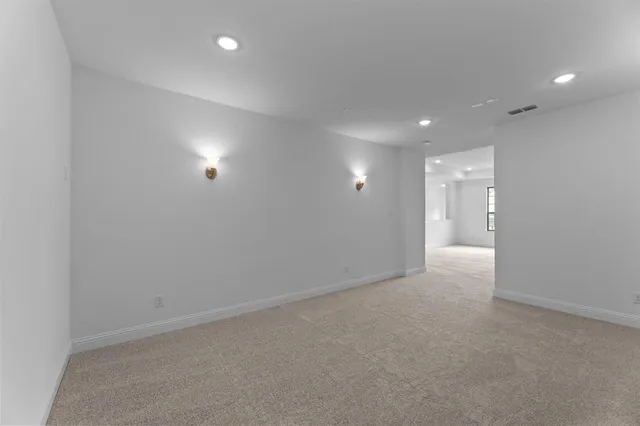 an empty room with white walls and windows