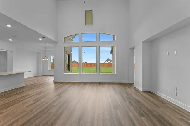 an empty room with wooden floor and a window