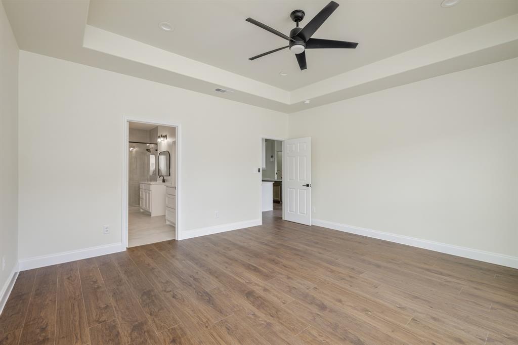 1844 County Road 2320 Terrell, TX 75160 - Photo 25 of 40 an empty room with wooden floor and a ceiling fan