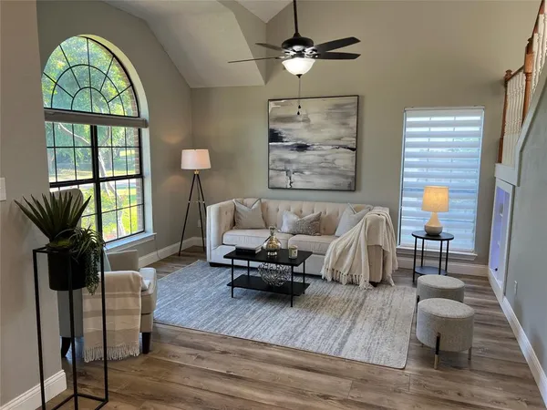 a living room with furniture and a wooden floor