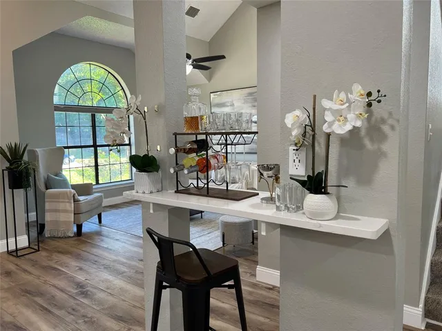 a dining room with wooden floor and a large window