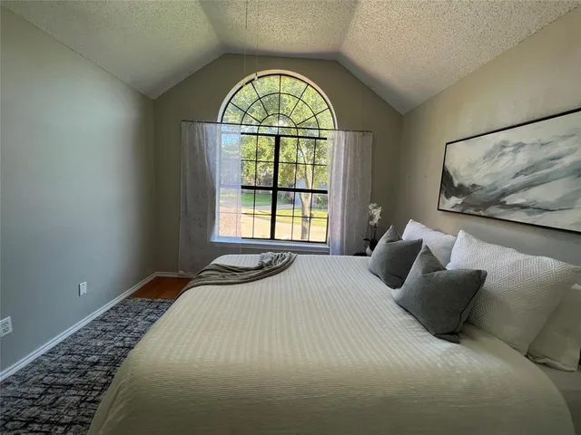 a bedroom with a bed and a large window