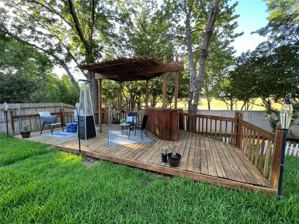 a view of backyard with deck and outdoor seating