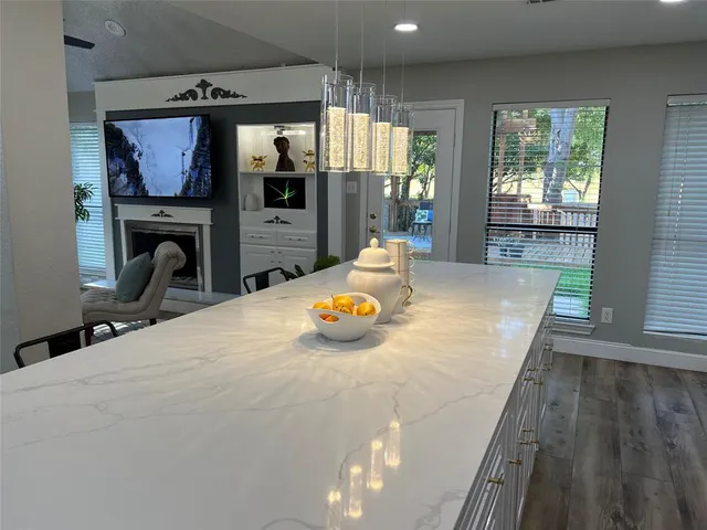 a view of a living room and kitchen with furniture wooden floor and windows