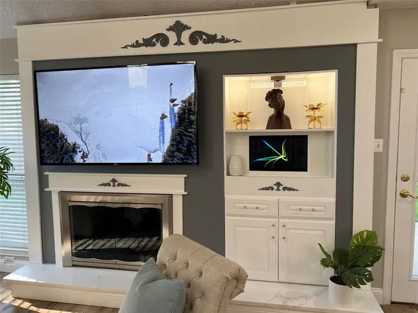 a living room with white cabinets and a fireplace