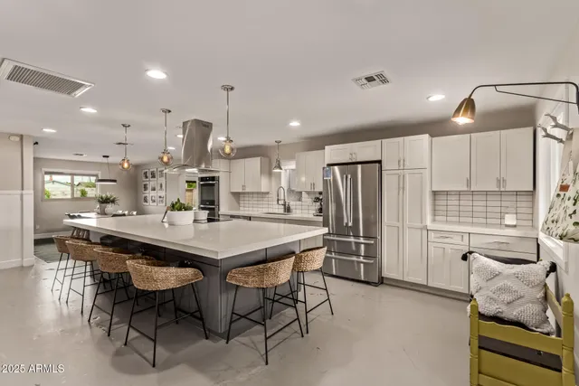 a kitchen with stainless steel appliances kitchen island granite countertop a sink and cabinets