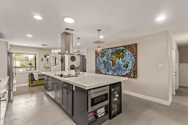 a large white kitchen with a large island oven a stove and a sink