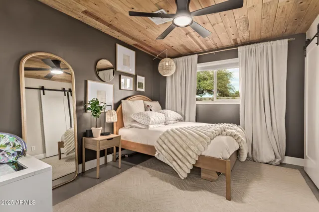 a bedroom with a bed mirror and window