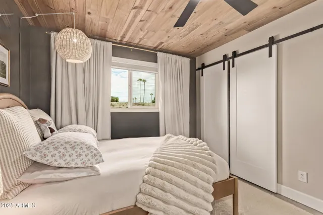 a bedroom with a bed mirror and window