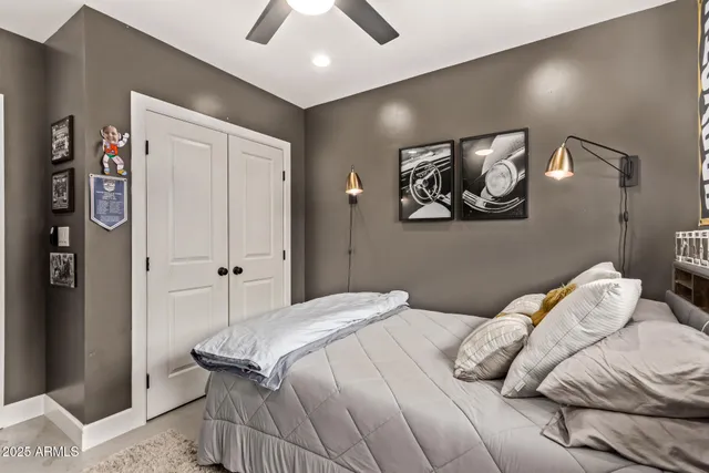 a bedroom with a bed and painting on the wall