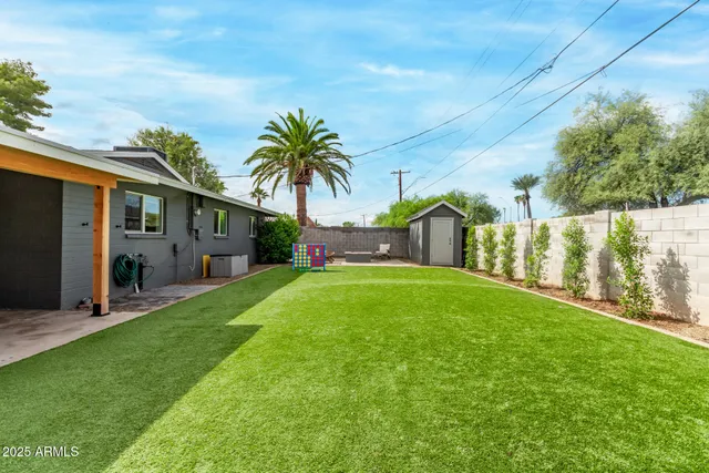 a view of house with backyard and a tree