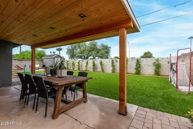 a view of a patio with a table chairs and a backyard