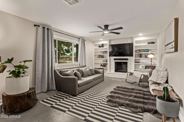 a living room with furniture a fireplace and a flat screen tv