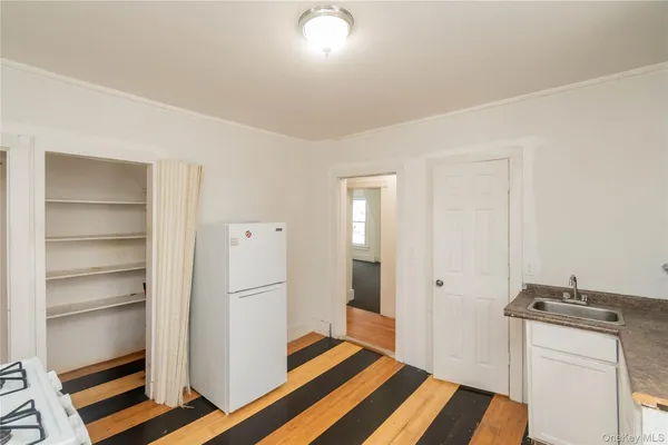 a room with a bed and a view of kitchen