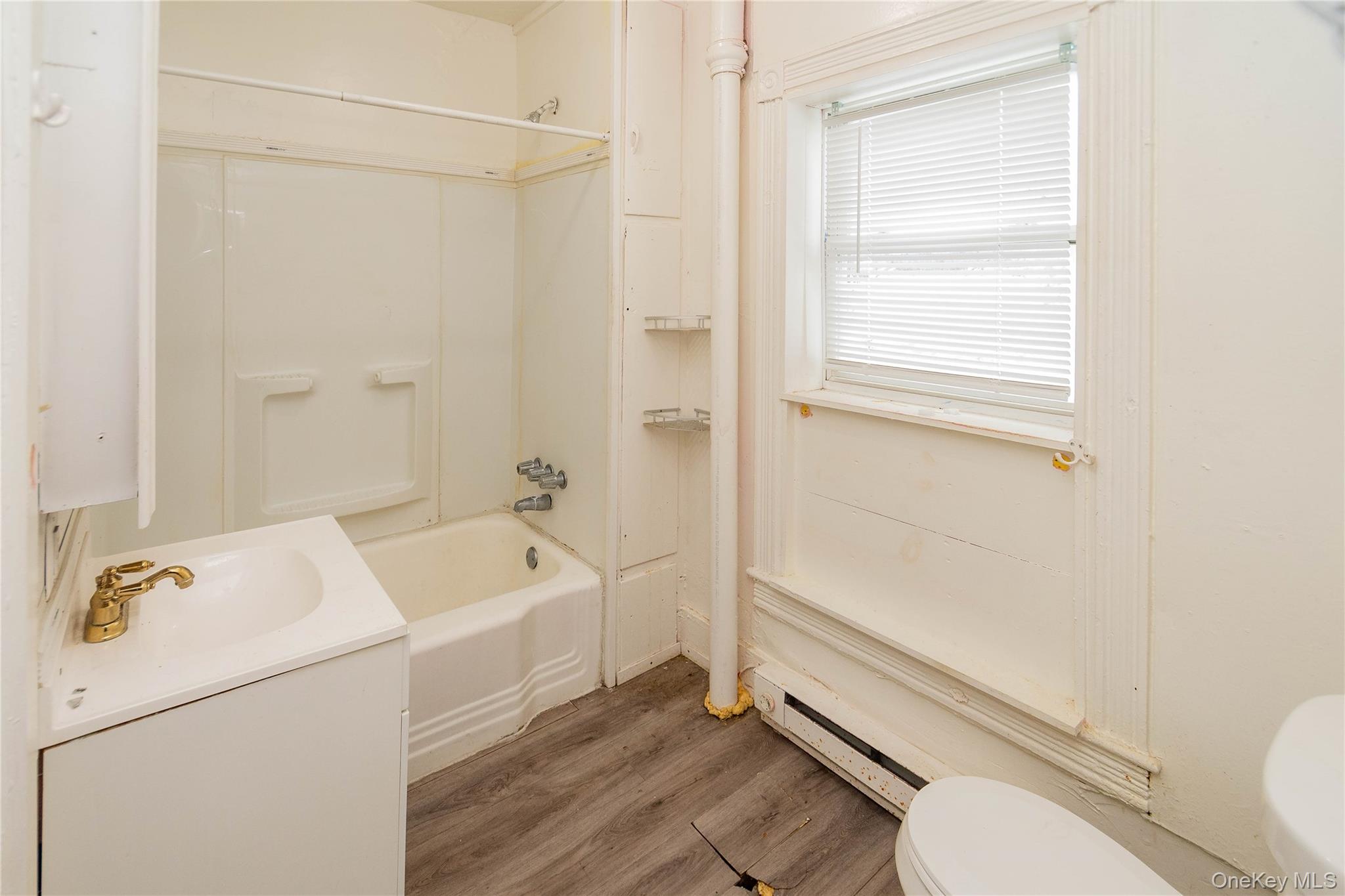 41 Edgar Street Liberty, NY 12754 - Photo 30 of 42 Bathroom featuring bathtub / shower combination, vanity, a baseboard radiator, and light wood-style floors