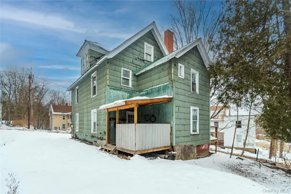 a view of a house with a yard covered in snow