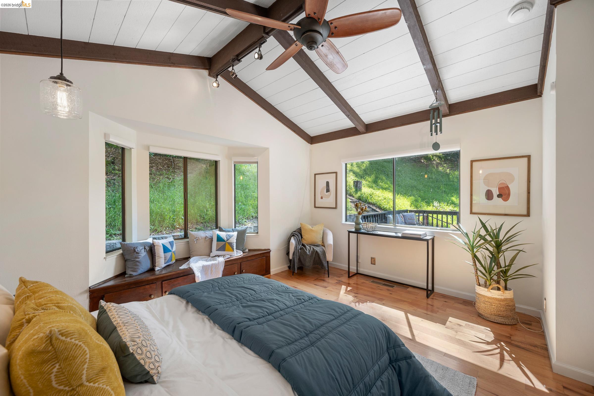 6600 Heather Ridge Way Oakland, CA 94611 - Photo 42 of 66 Vaulted ceiling featuring exposed beams, wood-finish flooring, a built-in window seat with integrated storage, and multiple windows