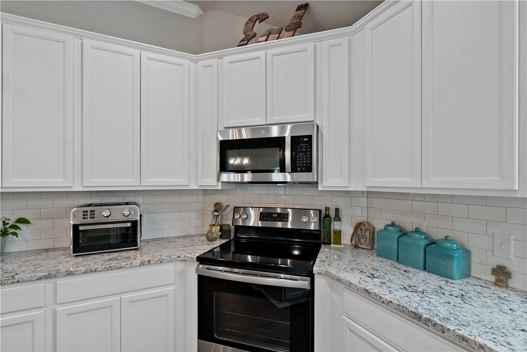 3161 Normandy Way Bryan, TX 77808 - Photo 15 of 27 a kitchen with granite countertop white cabinets and black stainless steel appliances