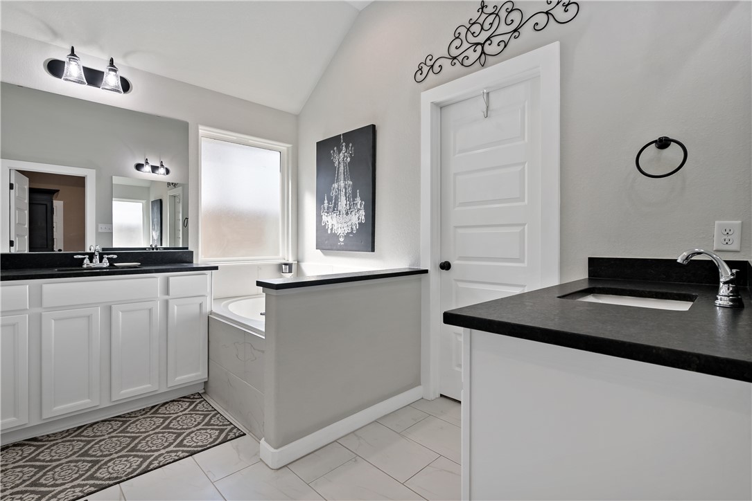 3161 Normandy Way Bryan, TX 77808 - Photo 17 of 27 a kitchen with granite countertop a sink white cabinets and a granite counter tops