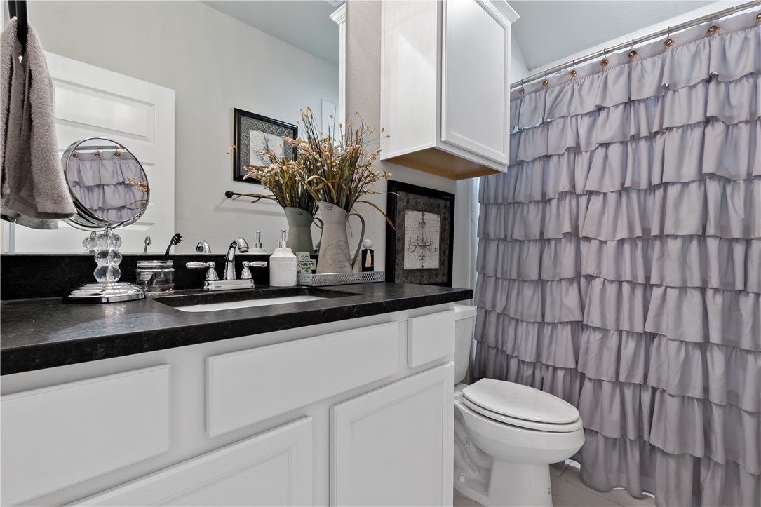 3161 Normandy Way Bryan, TX 77808 - Photo 21 of 27 a bathroom with a toilet a sink and a mirror