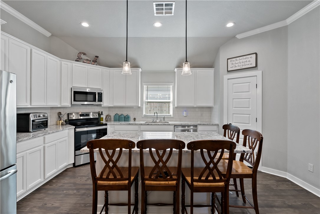 3161 Normandy Way Bryan, TX 77808 - Photo 10 of 27 a kitchen with a table chairs microwave and cabinets