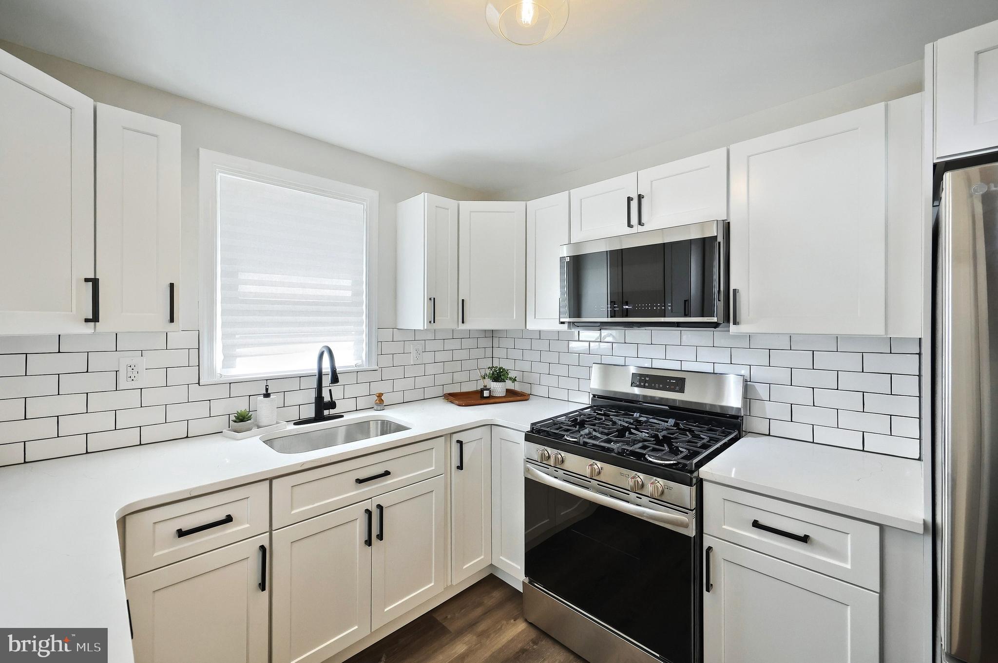 6414 Liberty Road Baltimore, MD 21207 - Photo 26 of 54 a kitchen with white cabinets appliances and a sink