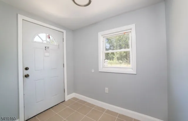 a view of an empty room with closet and a window