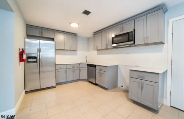 a kitchen with stainless steel appliances a refrigerator and microwave