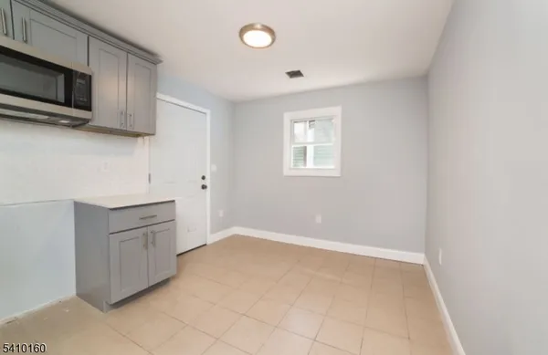 a kitchen with granite countertop white cabinets and stainless steel appliances