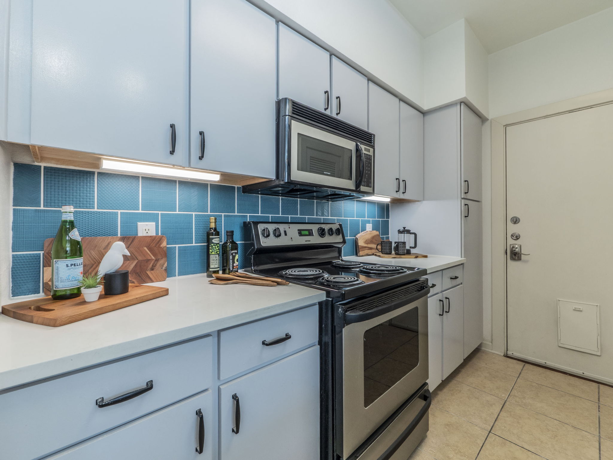1201 Grove Boulevard, Unit 702 Austin, TX 78741 - Photo 5 of 19 a kitchen with stainless steel appliances granite countertop a stove a sink and a microwave