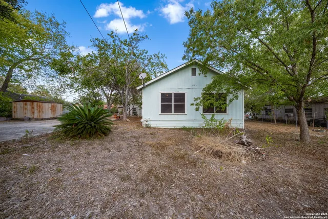 a view of a house with backyard and trees