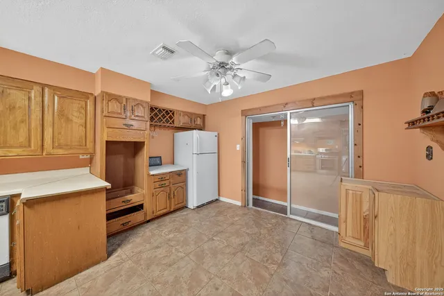 a view of a kitchen with refrigerator and ceiling fan