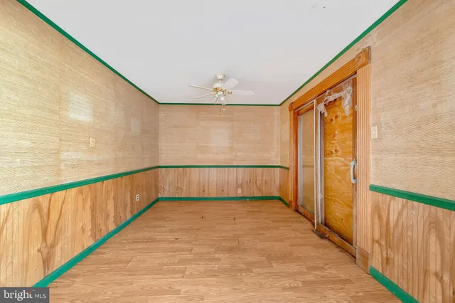 a view of a big room with wooden floor and windows
