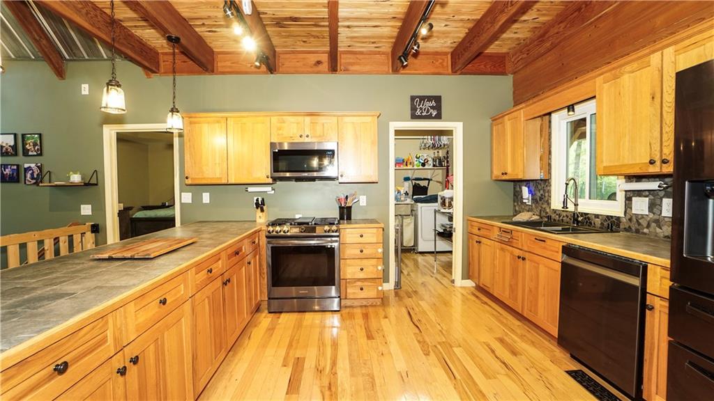 169 Williams Road Taylorsville, GA 30178 - Photo 11 of 84 a large kitchen with stainless steel appliances a stove a sink dishwasher a refrigerator and wooden cabinets with wooden floor