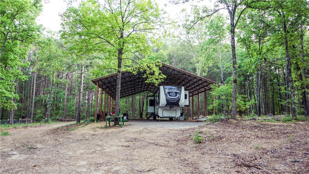 169 Williams Road Taylorsville, GA 30178 - Photo 10 of 84 a view of a wooden house with large trees and wooden fence