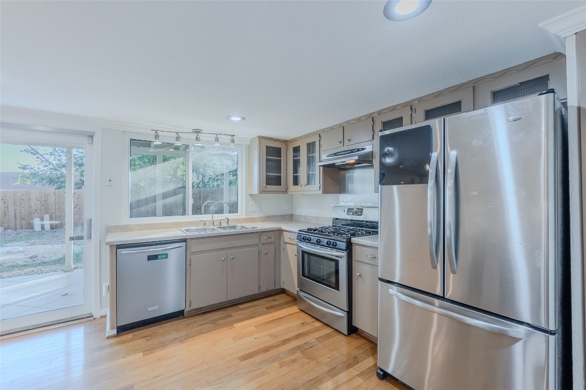8203 Beaver Brook Lane Austin, TX 78748 - Photo 10 of 34 a kitchen with stainless steel appliances a refrigerator sink and stove