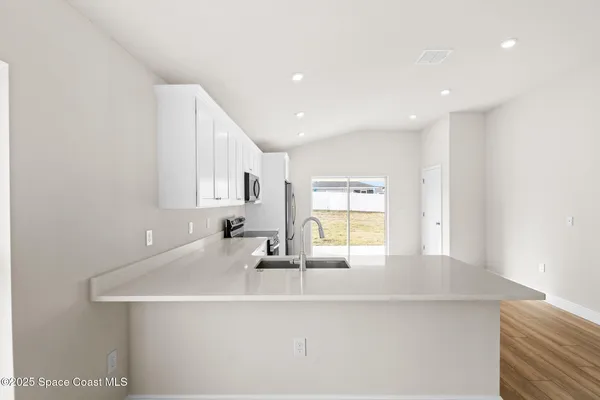 a kitchen with stainless steel appliances granite countertop a stove a refrigerator and a microwave