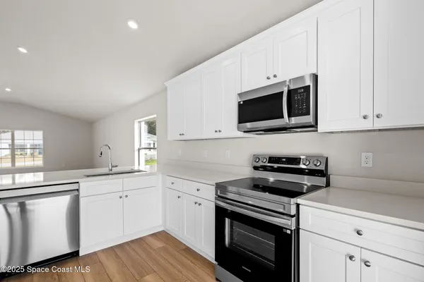 a sink with a white cabinets and wooden floor