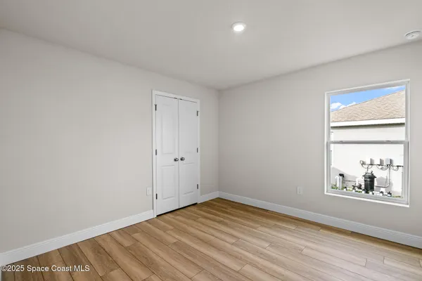 a view of an empty room with wooden floor
