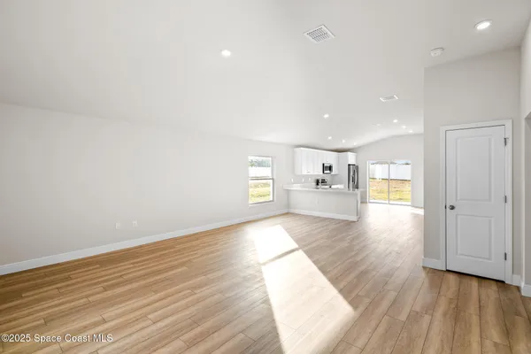 a view of a kitchen with wooden floor and a kitchen