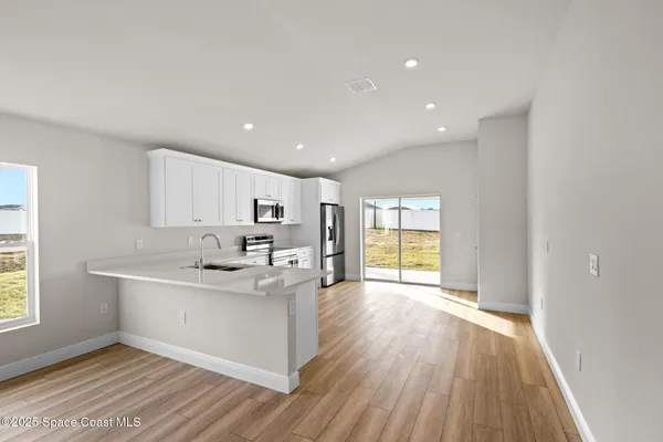 a kitchen with kitchen island a sink and a stove with wooden floor