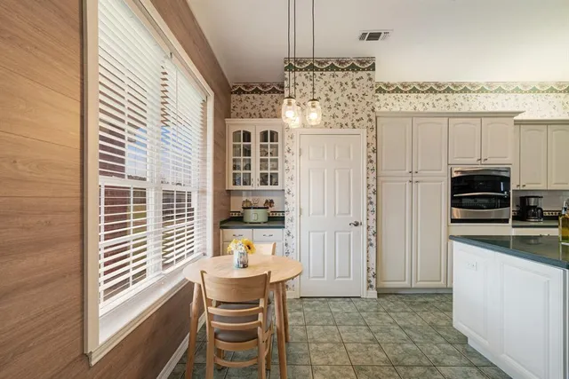 a kitchen with kitchen island granite countertop stainless steel appliances and white cabinets
