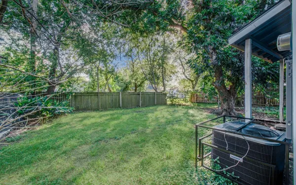 a view of a backyard with couches plants and large tree