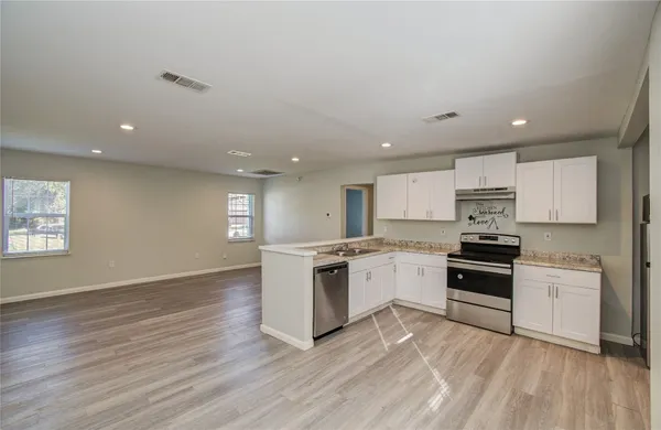 a kitchen with granite countertop a stove top oven and sink